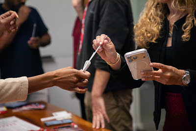 Person participating in a cheek swab donor registration activity supporting DKMS blood stem cell donor awareness